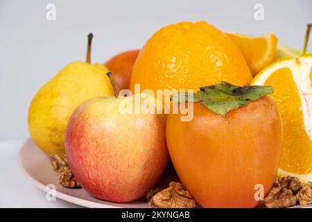 Früchte von orangen und gelben Farben - Äpfel, Kaki, Birnen und Orangen. Stockfoto