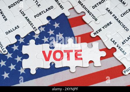 Nationales Konzept. Die US-Flagge hat Rätsel mit dem Namen der Stadt und Rätsel mit der Inschrift Vote Stockfoto