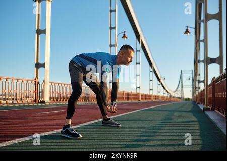 Fitness-Läufer macht vor dem Laufen ein Aufwärmprogramm Stockfoto
