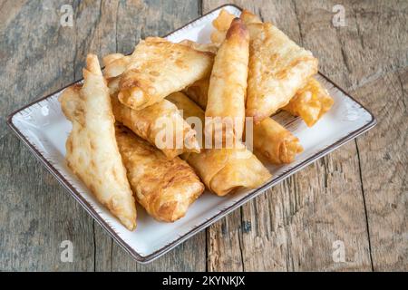 Phyllo-Gebäck, traditionelle Frühlingsrollen, auch bekannt als „igara Boregi“ auf Türkisch, Türkei. Gebratenes Phyllo-Gebäck mit Käse auf Holztisch oder Hintergrund, fa Stockfoto