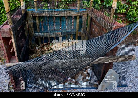 Komposthüllen aus alten Holzpaletten. Stockfoto