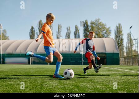 Porträt von Schuljungen, die Fußball auf dem Fußballfeld trainieren Stockfoto