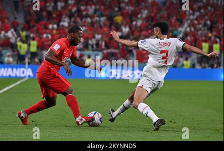 Doha, Katar. 1.. Dezember 2022. Noussair Mazraoui (R) aus Marokko spielt mit Junior Hoilett aus Kanada während des Group F-Spiels bei der FIFA-Weltmeisterschaft 2022 im Al Thumama Stadium in Doha, Katar, 1. Dezember 2022. Kredit: Chen Cheng/Xinhua/Alamy Live News Stockfoto