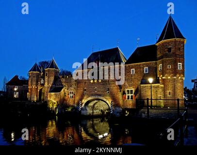 Dieses beleuchtete Tor namens Koppelpoort ist ein mittelalterliches Tor in der niederländischen Stadt Amersfoort. Es kombiniert Land- und Wassertore. Es ist Teil des zweiten Stockfoto