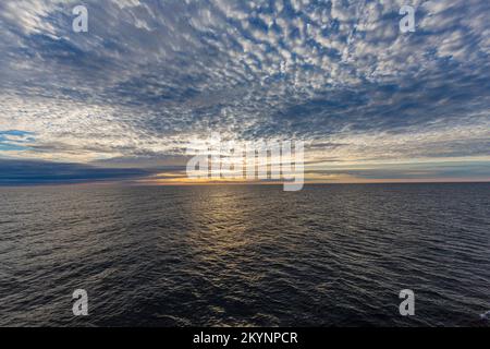 Bild eines dramatisch bewölkten Himmels auf dem Meer bei Sonnenaufgang Stockfoto