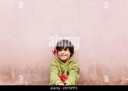 Glückliches lächelndes Mädchen mit kurzen Haaren an der rosa Wand Stockfoto