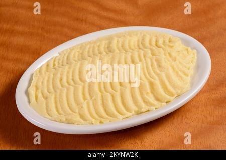 Kartoffelbrei. Kleine Portion in weißer Schüssel auf Holzhintergrund. Stockfoto