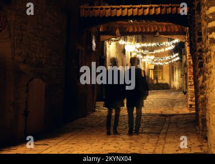 Ein paar Schatten auf der Straße in der Altstadt von Tallinn. Weihnachtsdekorationen auf der Straße. Stockfoto