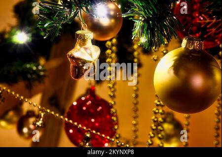 Weihnachtsdekoration mit goldenen und roten Objekten vor einem verschwommenen Hintergrund. Stockfoto
