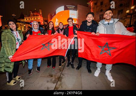 London, Großbritannien. 1.. Dezember 2022. Marokkanische Fans im Piccadilly Circus feiern, dass sie bis zur K.o.-Bühne der WM-Finals durchgekommen sind. Kredit: Guy Bell/Alamy Live News Stockfoto