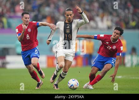 Deutschlands Leroy Sane (Zentrum) unter dem Druck von Costa Ricas Bryan Oviedo (links) und Jelzin Tejeda während des Gruppenspiels der FIFA-Weltmeisterschaft E im Al Bayt-Stadion, Al Khor, Katar. Foto: Donnerstag, 1. Dezember 2022. Stockfoto