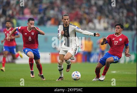 Deutschlands Leroy Sane (Zentrum) unter dem Druck von Costa Ricas Bryan Oviedo (links) und Jelzin Tejeda während des Gruppenspiels der FIFA-Weltmeisterschaft E im Al Bayt-Stadion, Al Khor, Katar. Foto: Donnerstag, 1. Dezember 2022. Stockfoto