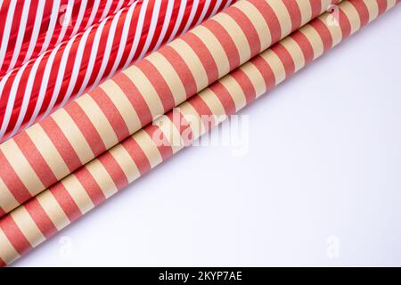 Rot-weiß und handgefertigte Gusspapierrollen auf weißem Hintergrund mit Kopierraum. Stockfoto