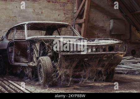 Altes zerlegtes Auto in einer verlassenen Fabrik Stockfoto