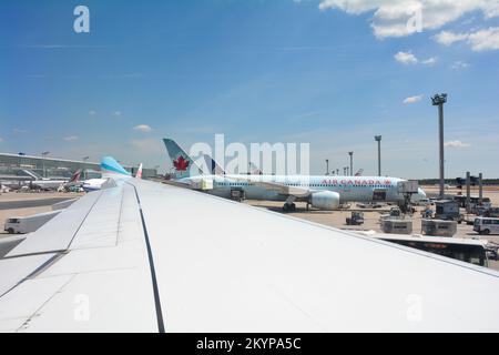 Flughafen Frankfurt, Deutschland 02. August 2022 - Blick vom Flugzeugfenster auf einen Flügel und Blick auf das Terminal und eine Air Canada Maschine ist niedrig Stockfoto