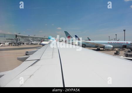 Flughafen Frankfurt, Deutschland 02. August 2022 - Blick vom Flugzeugfenster auf einen Flügel und Blick auf das Terminal und eine Air Canada Maschine ist niedrig Stockfoto