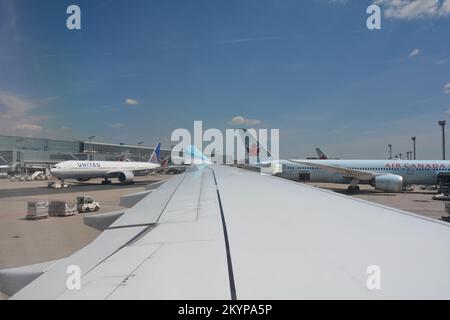 Flughafen Frankfurt, Deutschland 02. August 2022 - Blick vom Flugzeugfenster auf einen Flügel und Blick auf das Terminal, eine zusammengezogene Maschine wird bis d geschleppt Stockfoto