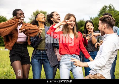 Multiethnische Gruppe von Freunden, die im Park tanzen - multiethnische Freunde, die Spaß auf dem Universitätscampus haben Stockfoto