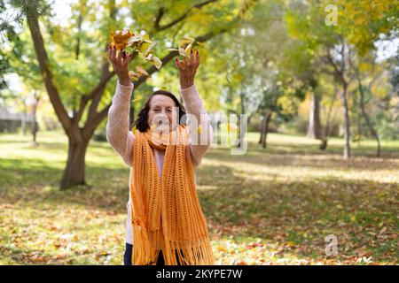 Ältere weiße Frau genießt einen Herbsttag im Freien. Platz für Text. Stockfoto