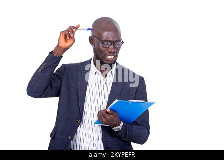 Ein junger, bärtiger Geschäftsmann in einer Jacke, der auf weißem Hintergrund steht und beim Nachdenken einen Ordner hält. Stockfoto