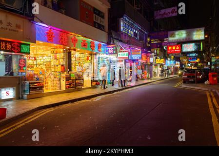 HONGKONG - 21. APRIL 2014: Tsim Sha Tsui Straßen bei Nacht. Tsim Sha Tsui, oft abgekürzt als TST, ist ein städtisches Gebiet im Süden von Kowloon, Hongkong. Stockfoto
