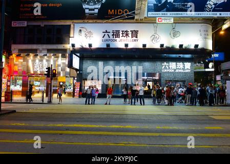 HONGKONG - 21. APRIL 2014: Tsim Sha Tsui Straßen bei Nacht. Tsim Sha Tsui, oft abgekürzt als TST, ist ein städtisches Gebiet im Süden von Kowloon, Hongkong. Stockfoto