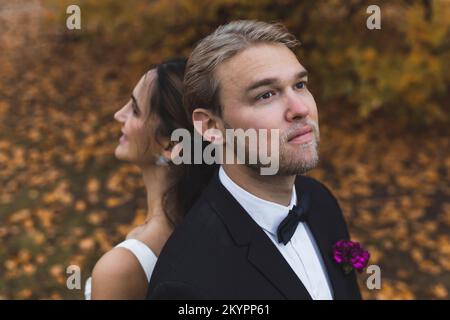 Braut und Bräutigam stehen mit dem Rücken zueinander. Hochwertiges Foto Stockfoto