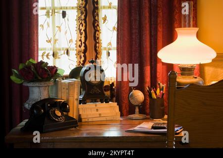 Antiker Schreibtisch und Stuhl im Wohnzimmer im alten, rekonstruierten 1977 Canadiana Cottage Stil Blockhaus. Stockfoto