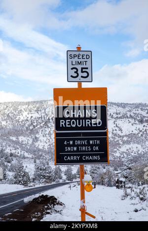 Schilder, die Autofahrer darauf hinweisen, dass Schneeketten erforderlich sind. State Route 139 in Lassen County California, USA. Stockfoto