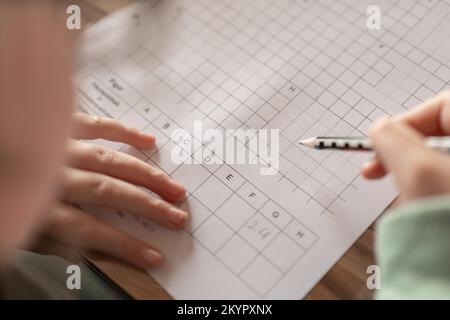 Hausaufgaben.Mathematikstunde.Student macht eine mathematische Aufgabe.Lernen und Bildungskonzept.Schulmädchen macht ihre Hausaufgaben. Stift in einem Kind Hand schreibt in A Stockfoto