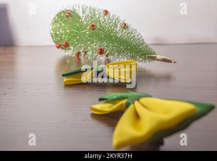 Fliege in den Farben Grün und Gelb Brasiliens und ein weihnachtsbaum fiel in den Hintergrund, Konzept von weihnachten und brasilien. Stockfoto