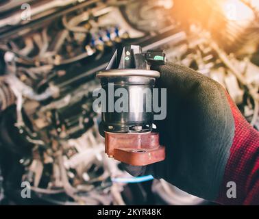 Nahaufnahme der EGR-Abgasrückführung in der Auto-mechanischen Hand, Fahrzeugteilekonzept. Stockfoto