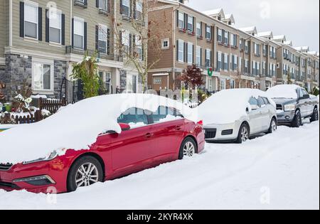 Auto unter Schnee im Winter. Geparkte Autos und die Straße sind mit einer glatten Schneeschicht bedeckt. Abdeckung mit Schneelinie von Fahrzeugen Schneefall bei Winter-Surre Stockfoto