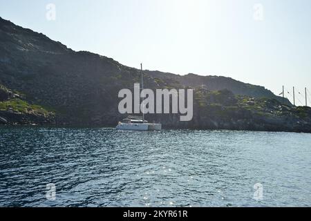 SANTORIN, GRIECHENLAND - 06. AUGUST 2015: Menschen auf einer Jacht nahe der Küste von Santorin. Santorini, klassisch Thera und offiziell Thira, ist eine Insel in der Stockfoto