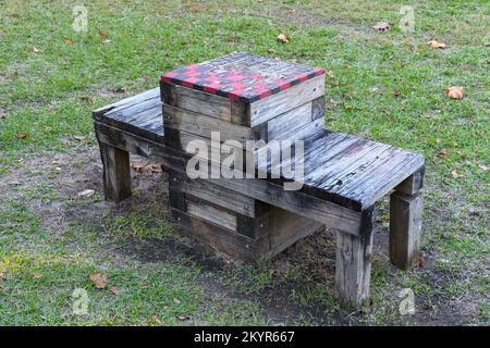 Im öffentlichen Park in New Orleans, Louisiana, USA, gibt es auch schwer verwitterte Checkers oder eine Kombination aus Schachbrett und Bank Stockfoto