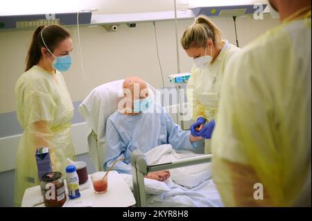 Berlin, Deutschland. 30.. November 2022. Julia Huk (l), ukrainische Rehabilitationsärztin, und Katja Hauswald, Physiotherapeutin, bieten im Unfallkrankenhaus Berlin Physiotherapie für einen Soldaten aus der Ukraine, der Brandverletzungen erlitten hat. Die Nachsorge von Verbrennungspatienten dauert oft Jahre. Ärzte aus dem Unfallkrankenhaus teilen ihr Fachwissen mit ukrainischen Ärzten und Ärztinnen, die hier zwei Wochen als Praktikanten verbringen. (Zu dpa 'Alltag im Krankenhaus trotz Krieg: Ukrainische Ärzte lernen in Berlin') Kredit: Annette Riedl/dpa/Alamy Live News Stockfoto