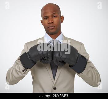 Bereit für den Firmenwettbewerb. Porträt eines gutaussehenden afrikanischen Geschäftsmanns mit Boxhandschuhen. Stockfoto