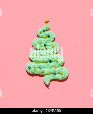 Grüne Buttercreme-Zuckerguss in Form eines Weihnachtsbaums mit farbigen Zuckerstreuseln als Weihnachtskugeln. Essbarer Weihnachtsbaum aus Minze fr Stockfoto