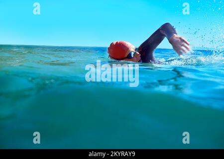 Ich genieße das kalte Süßwasser. Ein Schwimmer im offenen Meer. Stockfoto