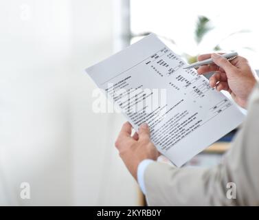 Sehen wir uns nun an, wie wir unser Bargeld nutzen... Kurzdarstellung eines Geschäftsmanns, der Finanzberichte prüft. Stockfoto