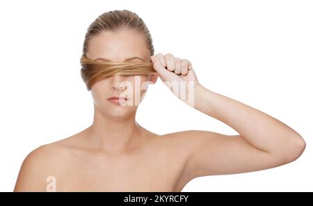 Auf gesundes, starkes Haar fokussiert. Eine wunderschöne, junge blonde Frau, die vor einem weißen Hintergrund posiert. Stockfoto