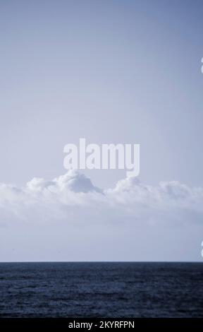 Weiße Cumulus Wolken über der blauen Oberfläche des Meeres an sonnigen Tagen. Schöner natürlicher Hintergrund. Bewegung der Wolken am Himmel. Himmelslandschaft. Seascape. Weiße blaue Farben. Zeitraffer. Stockfoto