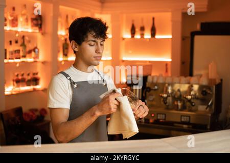 Der Barkeeper poliert das Weinglas in der Café-Bar. Speicherplatz kopieren Stockfoto