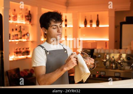 Arabischer Barkeeper, der das Weinglas in der Café-Bar poliert. Speicherplatz kopieren Stockfoto