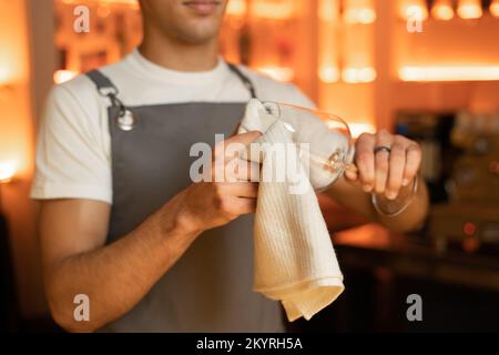 Der Barkeeper poliert das Weinglas und arbeitet in der Café-Bar. Speicherplatz kopieren Stockfoto