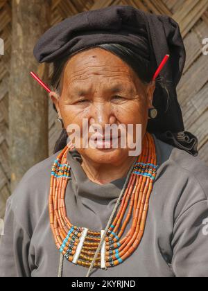 Mon District, Nagaland, Indien - 03 11 2014 : Porträt der alten Naga Konyak-Stammesfrau mit traditioneller Halskette und roten Stachelschweinen in den Ohren Stockfoto