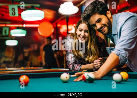 Paar dating, flirten und spielen Billard in einem Pub Stockfoto