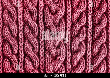 Strickstruktur in Rot Viva Magenta. Handgefertigte Strickmode. Strukturierter Hintergrund. Farbe des Jahres 2023 Stockfoto