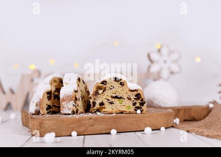 Scheiben von deutschem Stollenkuchen, ein Obstbrot mit Nüssen, Gewürzen und getrockneten Früchten mit Puderzucker, traditionell während der Weihnachtszeit serviert Stockfoto