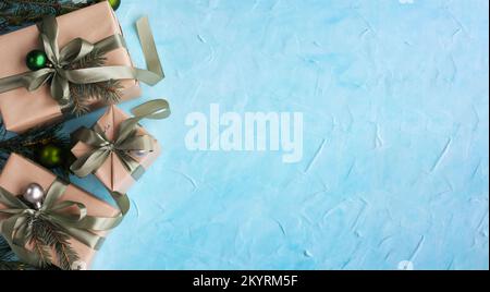 Weihnachtsbanner mit vielen Geschenkboxen mit Papierdekoration auf blauem Gipshintergrund. Hintergrund zu Weihnachten. Stockfoto